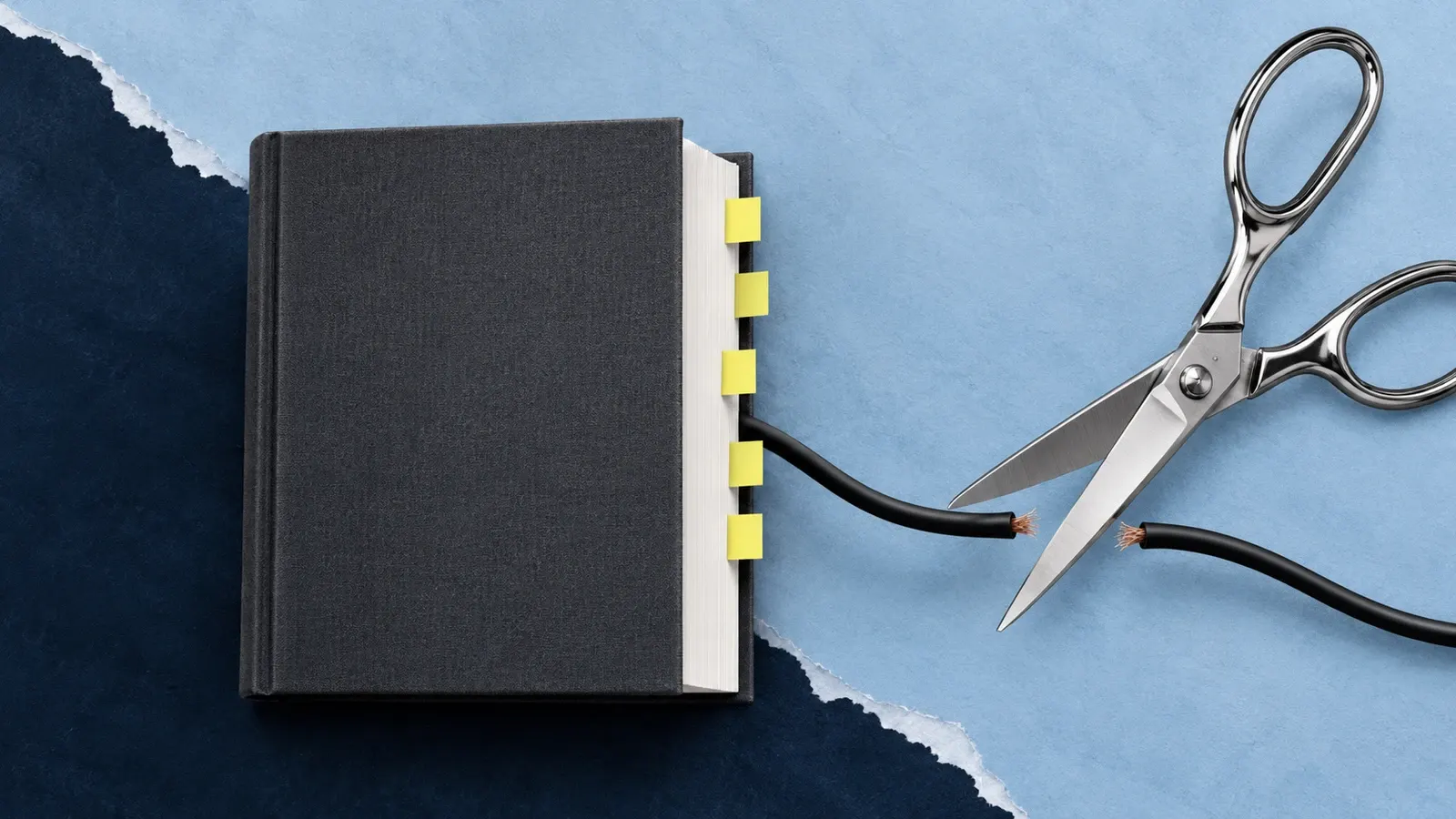Oversized silver scissors cut an unnecessary black cable beside a tabbed book on torn blue paper.